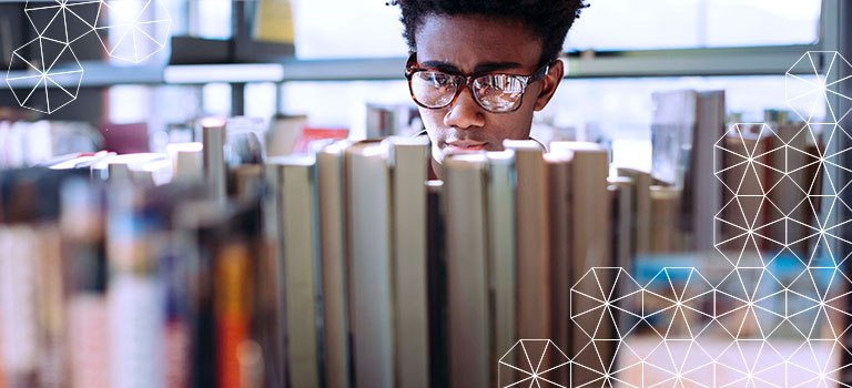 person looking through a stack of books at a library